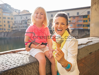 Closeup on smiling mother and baby girl showing ice cream near p