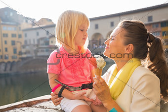 Happy mother and baby girl eating ice cream near ponte vecchio i