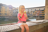 Portrait of happy baby girl eating ice cream near ponte vecchio 