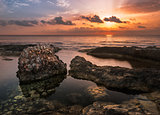 Sunset over the Sea and Rocky Coast with Ancient Ruins