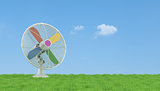 Colorful electric fan on grass