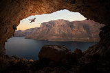 Female rock climber falling of a cliff in a big cave at Kalymnos, Greece