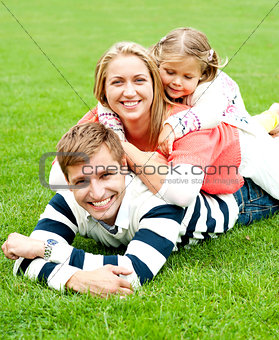 Young mother sandwiched between her daughter and husband