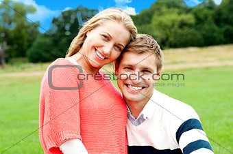 Young couple outdoors sitting on green grass
