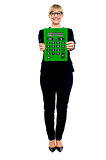 Woman in business suit displaying large green calculator