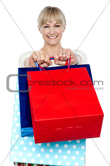 Woman holding shopping bags in her outstretched arms