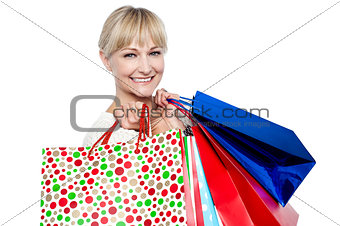 Pretty female carrying shopping bags over shoulders
