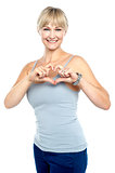 Romantic middle aged woman gesturing heart shape