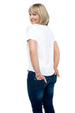 Smartly dressed woman with hands in back pocket of jeans