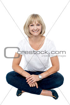 Smiling middle aged woman sitting on the floor
