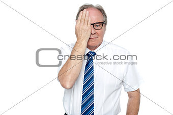 Manager with hand on right eye looking at you