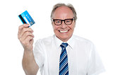 Cheerful aged employer holding up a cash card