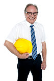 Smiling experienced architect posing with safety helmet
