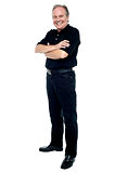 Happy man in black attire posing with arms folded