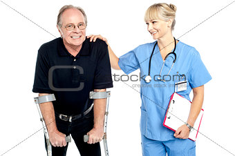 Cheerful doctor encouraging her patient to walk with crutches
