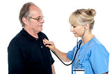 Female doctor examining an elderly man