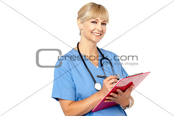Physician with clipboard smiling at camera