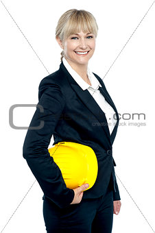 Pretty business architect with yellow safety helmet in hand