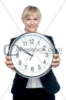 Business executive displaying big wall clock