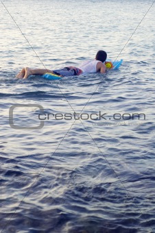 Boy swimming on a raft