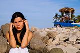 Girl sitting on rocky beach