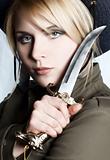serious blond nordic girl with sharp knife in her hand
