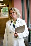 female medical professional with clipboard in hallway