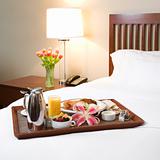 Breakfast tray on white bed.