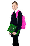School girl posing with backpack and calculator