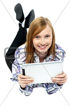 Girl relaxing on studio floor and browsing her new tablet