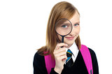 Teenager looking through a magnifying glass