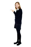 Student standing sideways and pointing forward