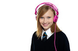 Cute teenager listening to music through headphones