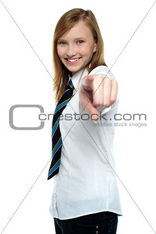 Cheerful young girl pointing towards the camera