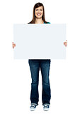 Trendy woman showing blank billboard to camera