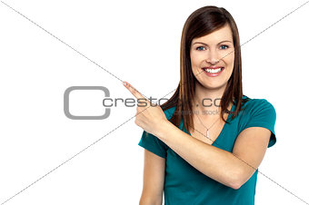Attractive lady pointing towards copy space area