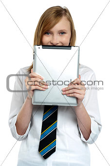 Shy girl hiding her face with a tablet device