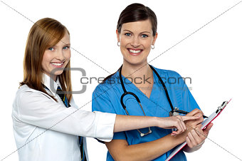 Attractive girl pointing at the doctors case sheet
