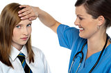 Doctor placing her hand on a patients forehead