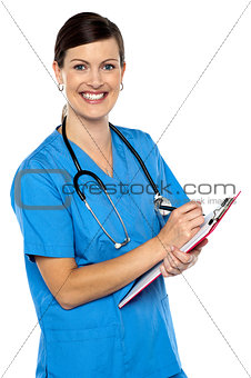 Smiling medical practitioner filling out the records