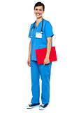 Nurse wearing blue uniform and holding red clipboard