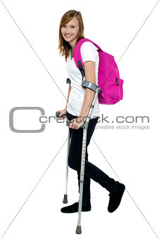 University student walking with help of crutches