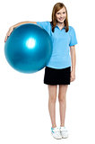 Slim and fit teen girl holding a swiss ball