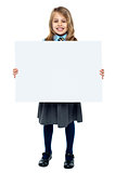 Cheerful schoolkid showcasing blank whiteboard