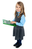 Schoolkid pressing key 5 on big green calculator
