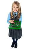 Pretty child in school uniform using calculator