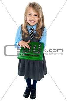 Pretty child in school uniform using calculator
