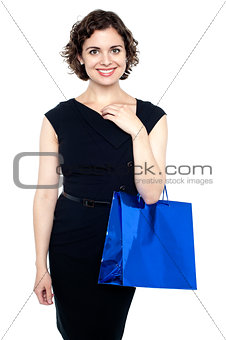 Young shopaholic woman carrying bright bag