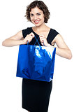 Cute young lady with a blue shopping bag
