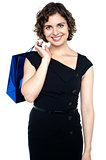 Attractive shopaholic woman carrying shopping bag